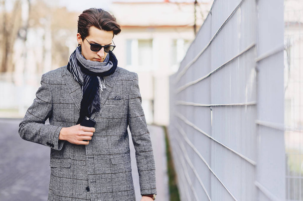 Stylish boy in sunglasses in coat with briefcase on street - Foto, immagini
