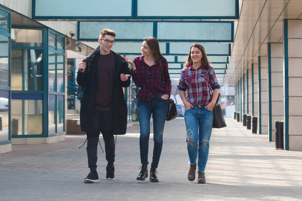 Tres estudiantes caminando y sonriendo
 - Foto, imagen