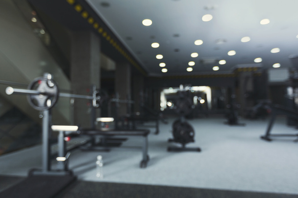 verschwommenes Fitnessstudio-Interieur mit Gewichtheben-Geräten - Foto, Bild