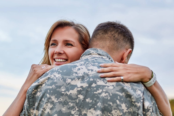 ΠΙΣΩ ΟΨΗ, ώριμη στρατιώτης αγκαλιάζει με τη σύζυγό του. - Φωτογραφία, εικόνα