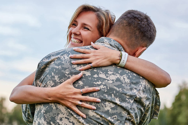 Happy woman hugging his husband came back from army. - Foto, Imagem