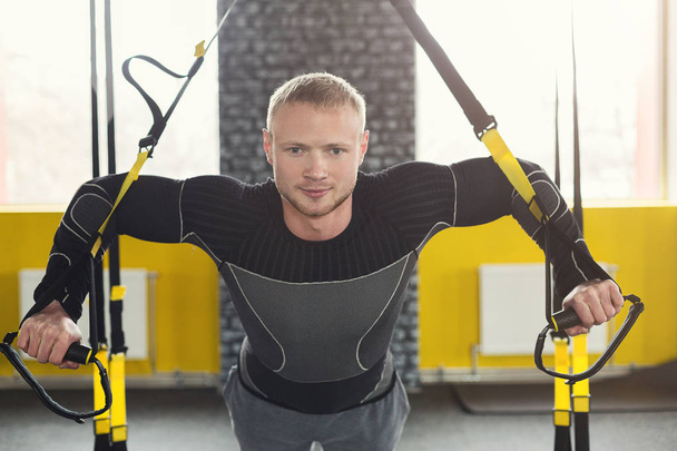 Hombre realizando entrenamiento de suspensión TRX en gimnasio
 - Foto, imagen
