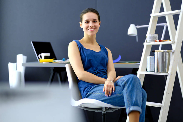 Young woman sitting on the desk in office - Foto, Imagen