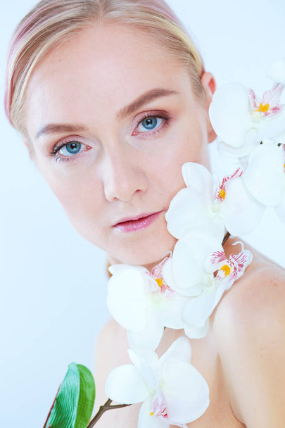 Young beauty woman with flower near face. - Valokuva, kuva