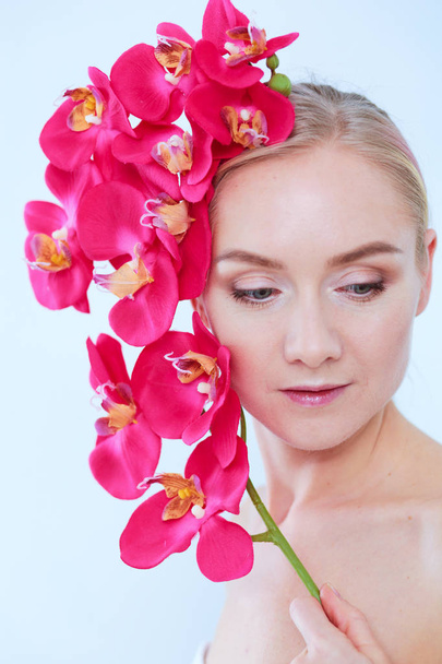 Young beauty woman with flower near face. - 写真・画像