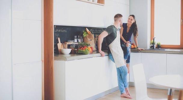 Beautiful young couple is having fun in kitchen at home - Fotografie, Obrázek