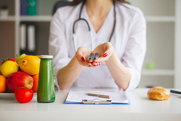 Ernährungsberaterin hält Blasen mit Pillen in der Hand - Foto, Bild