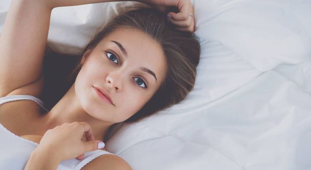 Young beautiful woman lying in bed - Фото, изображение