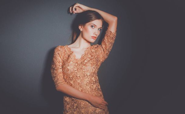 attractive woman in gold dress - Foto, afbeelding