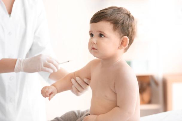 Doctor vaccinating baby in clinic - Фото, зображення