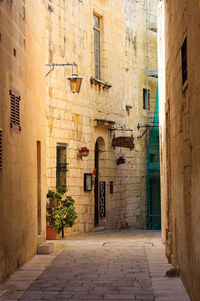 Malta, Mdina. Un restaurante en la antigua ciudad medieval con las calles estrechas y las fachadas de arenisca
 - Foto, imagen