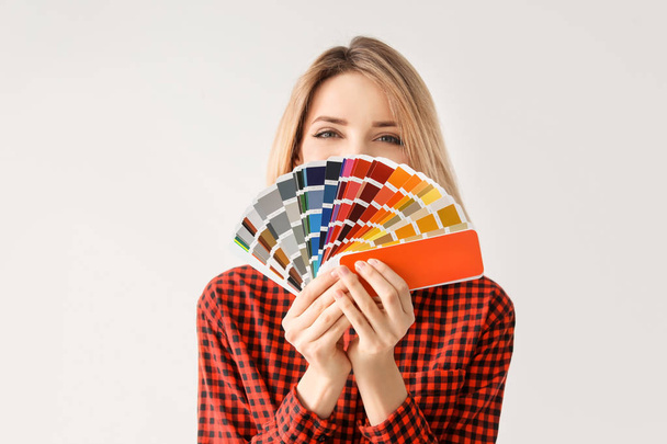 Young woman with color palette on white background - Фото, зображення