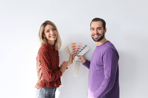 Young couple with color palette on white background - Fotografie, Obrázek