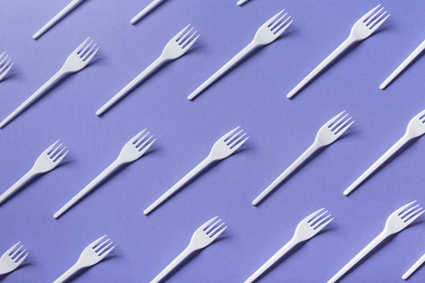 Vista dall'alto su forchette di plastica su sfondo viola
 - Foto, immagini