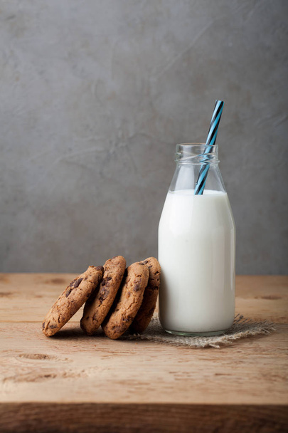 Pullo maitoa ja suklaa siru evästeet tumma tausta kopioi tilaa
 - Valokuva, kuva