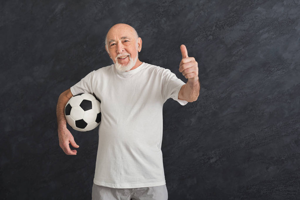 Старший мужчина с футбольным мячом показывает большой палец вверх
 - Фото, изображение