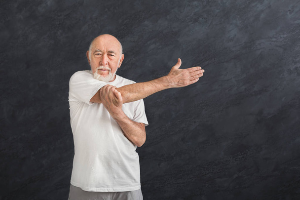 Senior man stretching hands indoors - Photo, Image