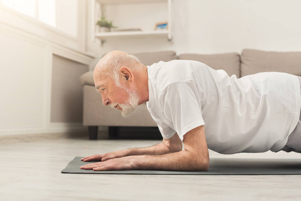 Senior man fitnesstraining, push-ups of plank - Foto, afbeelding