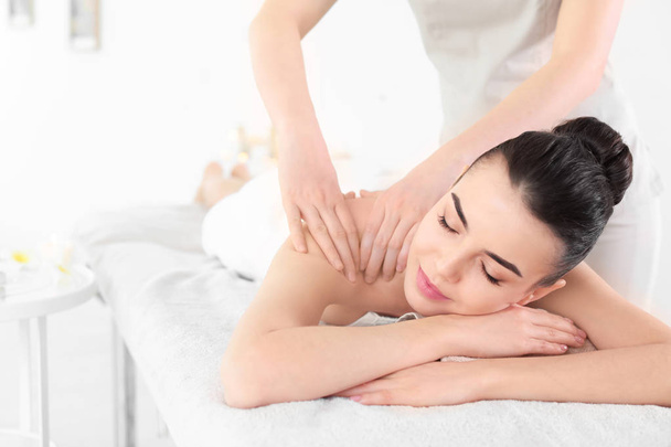 Young woman receiving massage in spa salon - Fotoğraf, Görsel