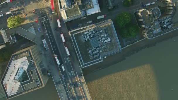 Aerial sunrise view commuter vehicles and pedestrians crossing London Bridge rooftops and rail tracks England UK  - Filmmaterial, Video