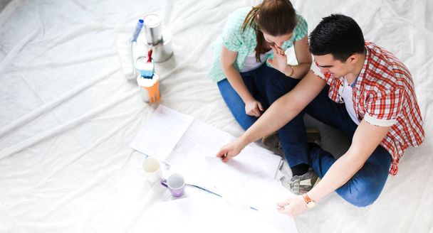 Young couple sitting on floor and calculating about they savings. Young couple - Foto, imagen