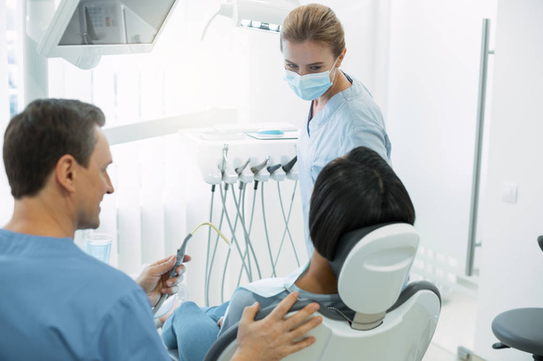 Professional dentist looking at her patient - Fotoğraf, Görsel