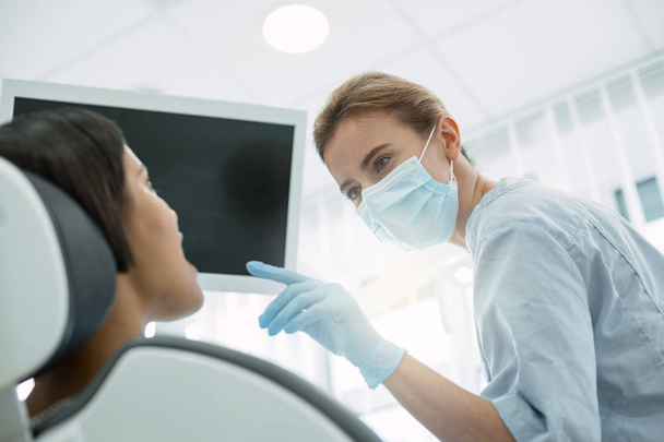 Skilled dentist examining her patients teeth - Zdjęcie, obraz