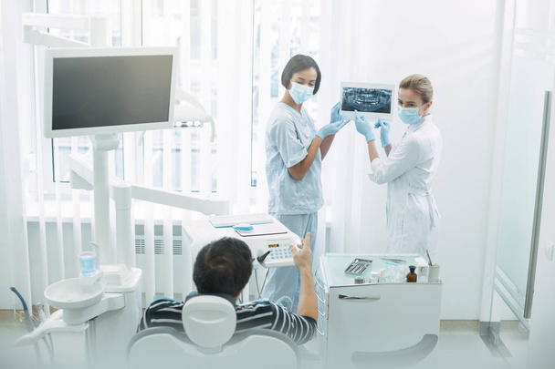 Professional dentists showing teeth on the screen - Фото, изображение