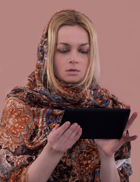 mujer con el pañuelo oriental usando la tableta
 - Foto, imagen