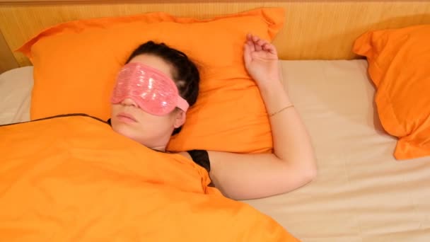 Vidéo 4k de la jeune femme endormie portant un masque pour les yeux. Réveille-toi et enlève le pansement. Conscient qu'il a trop dormi
 - Séquence, vidéo