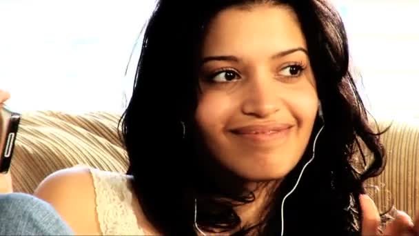 Hermosa chica latina en el sofá con su reproductor de MP3
 - Imágenes, Vídeo