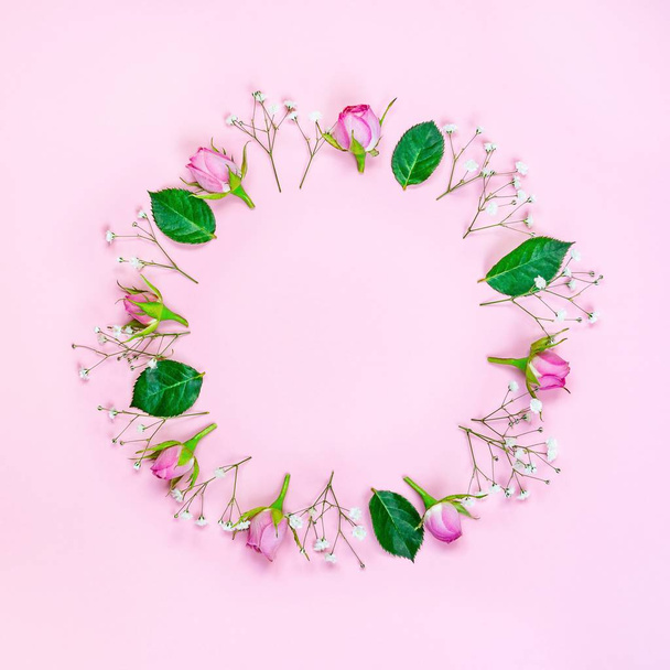 ピンクのバラとピンクの背景の上の緑の葉の花輪の平面図です。抽象的なフローラル背景. - 写真・画像