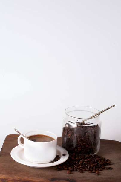 Кофейная чашка и бобы на кухонном столе. Вид сверху с помощью кописпы
 - Фото, изображение
