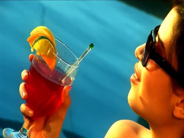 Закри Latino красуню розслабляючись з коктейлем біля басейну - Кадри, відео
