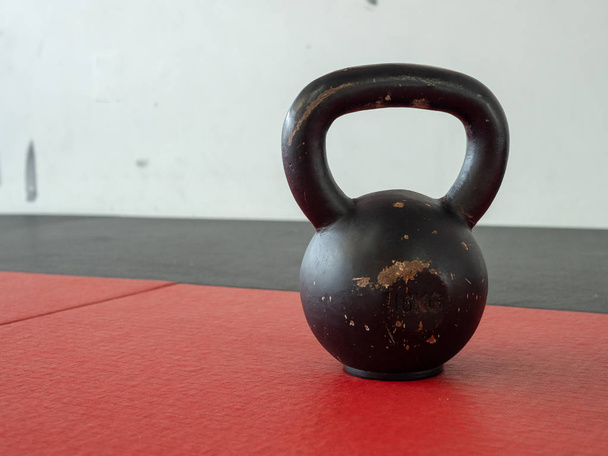Cloche de bouilloire de 10 kg assise sur un tapis de gym avec de l'espace à gauche
 - Photo, image