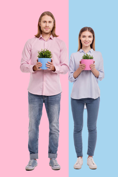 Cheerful couple showing matching flower pots - Valokuva, kuva