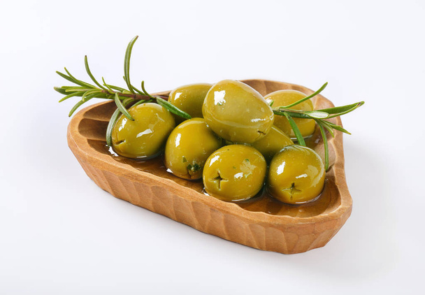 Kom met groene olijven met rozemarijn - Foto, afbeelding