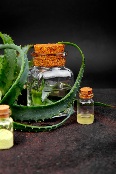 Aloe vera oil in glass bottle and towel for spa on brown background. Star cactus, Aloin, Jafferabad, Aloe barbadensis, Barbados herbal medicine for skin treatment and care. - Φωτογραφία, εικόνα