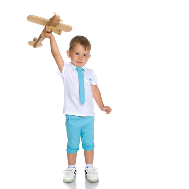 Little boy playing with wooden plane - Foto, Imagen