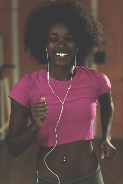 afro american woman running on a treadmill - Фото, зображення
