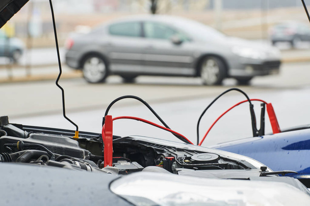 Automobile help. booster jumper cables charging automobile discharged battery - Fotó, kép