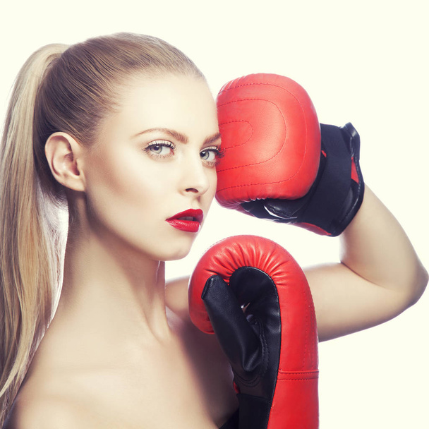 Modèle de mode avec maquillage lèvres rouges et gants de boxe sur fond blanc
 - Photo, image