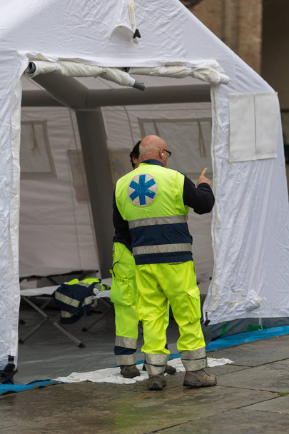 Medici che parlano fuori dalla tenda del centro di controllo temporaneo di salvataggio bianco
 - Foto, immagini