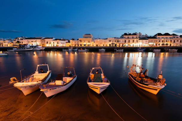 Tavira, Portugal - April 11; 2018: Fishing boats at the bank on the Gilao River in the Old Town of Tavira, Algarve, Portugal. - Photo, image
