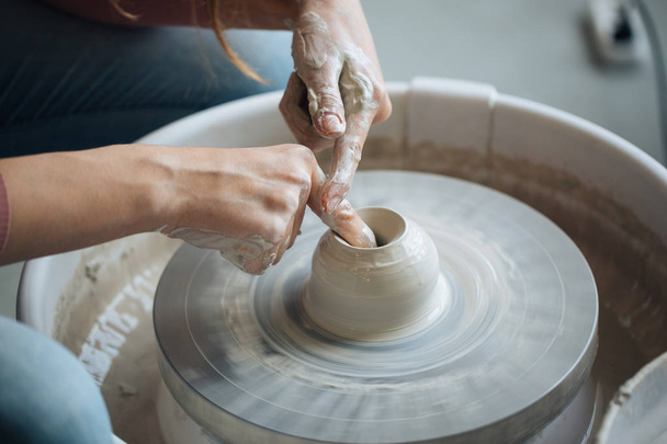 Handcrafted on a potter's wheel,Hands make clay from various items for home and sale in the store and at the exhibition, ceramic items are made in hand, the clay billet becomes a ceramic dish - Foto, imagen
