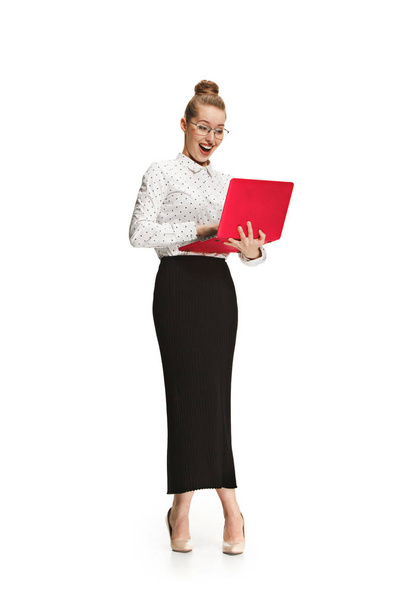 Full length portrait of a smiling female teacher holding a laptop isolated against white background - Photo, image