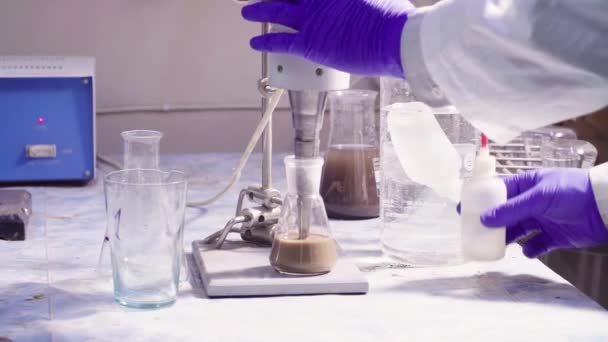 Mãos de cientistas tirando o agitador do frasco
 - Filmagem, Vídeo