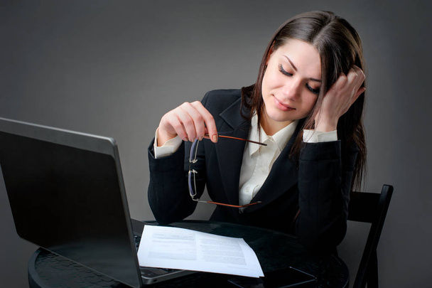 femme d'affaires avec ordinateur portable est conçu avec des documents sur fond gris
 - Photo, image