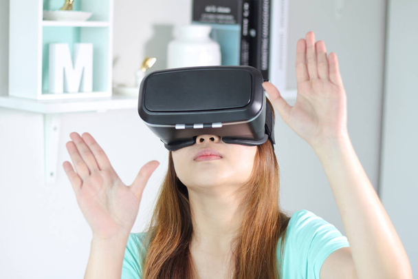 Nuori nainen yllään virtuaalitodellisuus lasit kotona
. - Valokuva, kuva