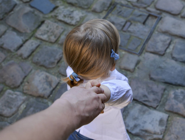 Una niña coge la mano de su padre
 - Foto, Imagen